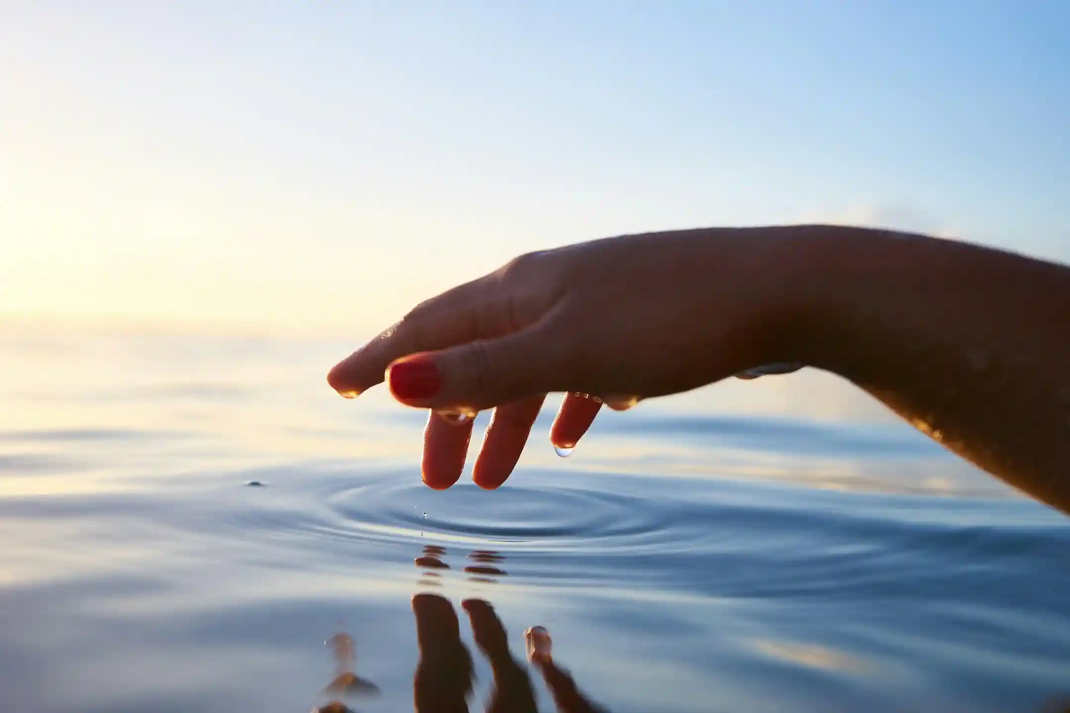 Fingers dipping in water